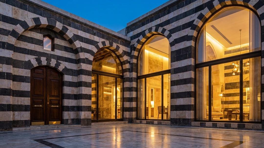 Restored Damascene courtyard blending ablaq stone and modern glass in Damascus Syria